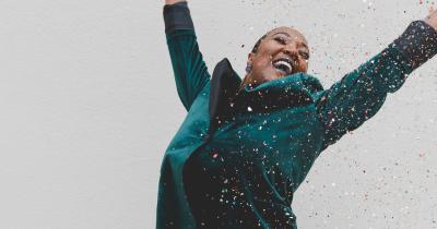 Excited woman with arms raised