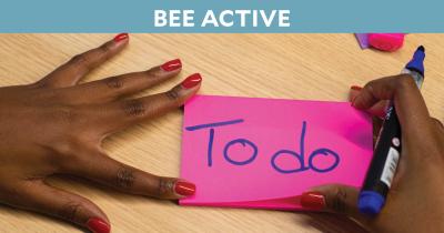 Woman holding marker and notecard reading "To do"