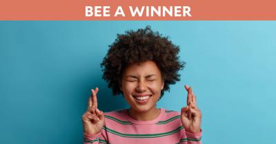 Bee a Winner Hero: Excited woman with fingers crossed.