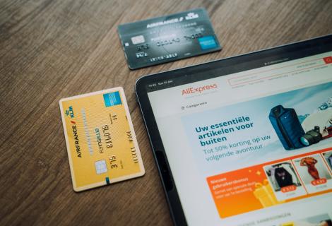 Picture of a tablet sitting on a table with two credit cards displayed on the table