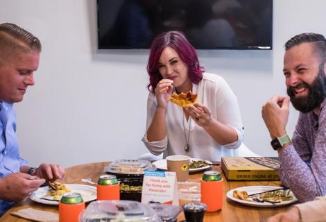 Picture of 3 people sitting around a table eating lunch